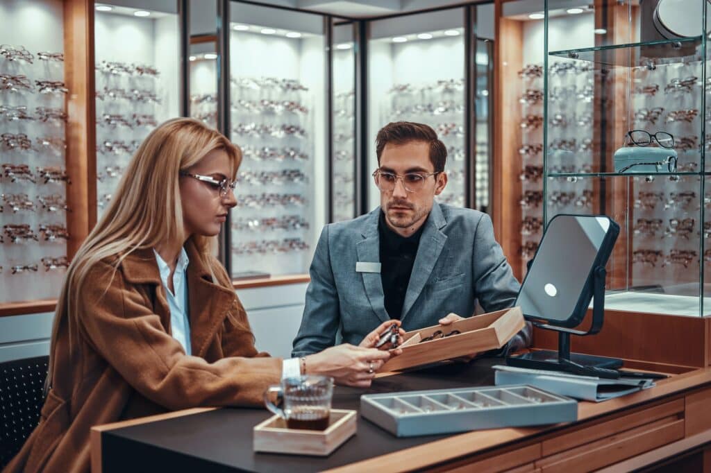 Lady is choosing new glasses at store