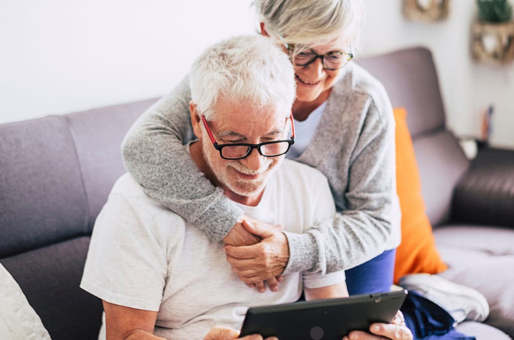 Elderly couple wearing glasses looking at a tablet screen